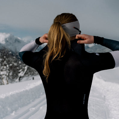 Skiier adjusting the back of the Trimtex Ace Biathlon Racesuit showing the breathable mesh fabric texture.