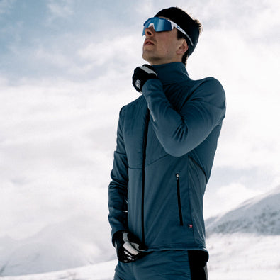 Skiier pulling up the zipper of his Trimtex Ace Primaloft skiing jacket in the mountains.