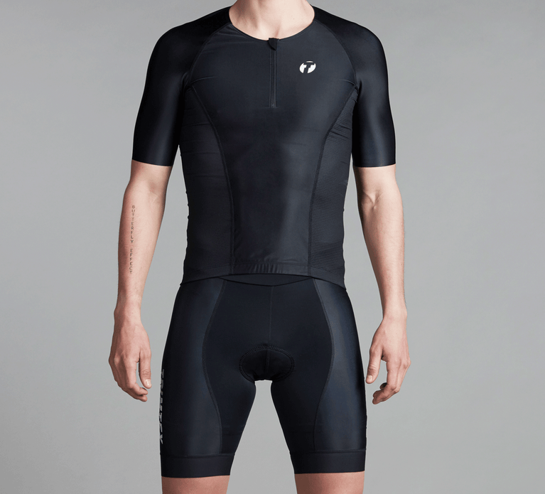 Studiophoto of a triathlete wearing the Drive shirt and shorts