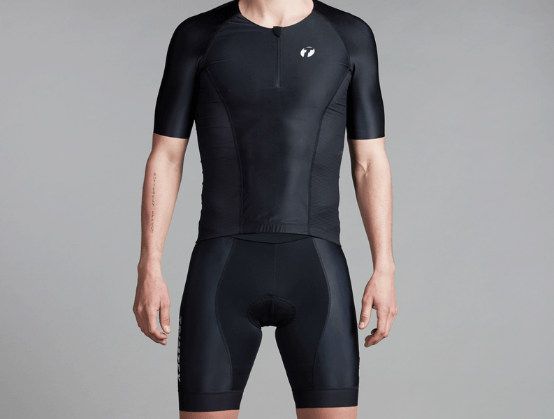 Studiophoto of a triathlete wearing the Drive shirt and shorts