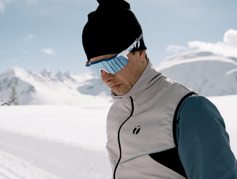 Skiier standing at ski tracks, wearing Trimtex Pulse skiing vest, Pulse jacket and Pulse beanie.