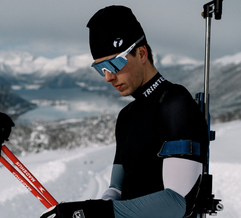 Biathlete getting ready to ski, wearing Trimtex Pulse Merino cap and Ace Biathlon racesuit.